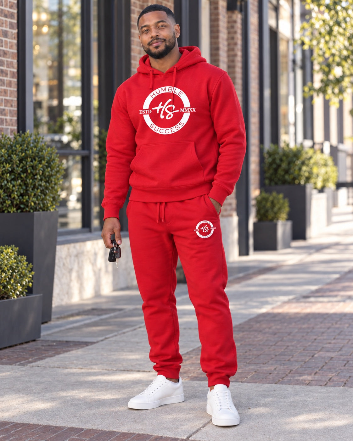 Male model wearing the Humble Success bold red hoodie and matching joggers